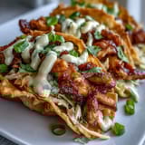 Golden fried wonton shells cradle smoky seasoned chicken and tangy slaw for Crispy Chicken Wonton Tacos topped with spicy mayo.