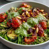 Savory Arugula Pesto Bowl featuring golden roasted bell peppers and cherry tomatoes on a bed of fresh arugula.