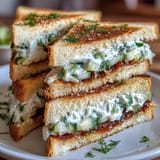 Delicate Mothers Day Tea Party Sandwiches with Lemon Butter, served with fresh cucumber and herbs.