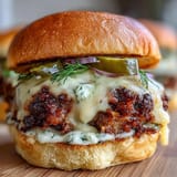 Crispy-edged beef patties on toasted brioche buns, layered with pickles, lettuce, and creamy secret sauce for a festive holiday meal.  