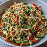 Chilled soba noodle salad, glistening with homemade sesame ginger dressing, ready for lunch.