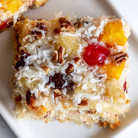 A beautiful slice of fruit cocktail cake, perfect dessert, with a light, fluffy coconut topping.