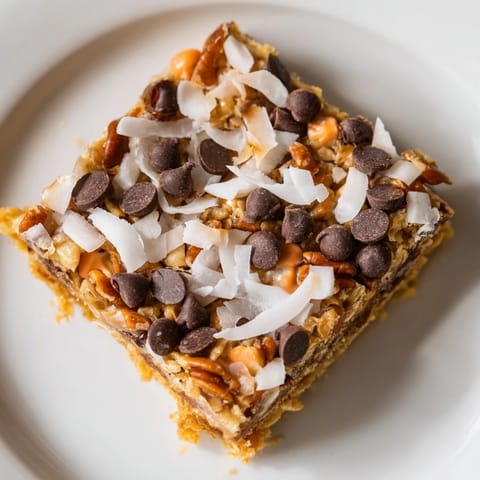 Chewy and layered Magic Cookie Bars, showcasing melted chocolate chips and a buttery graham cracker crust.
