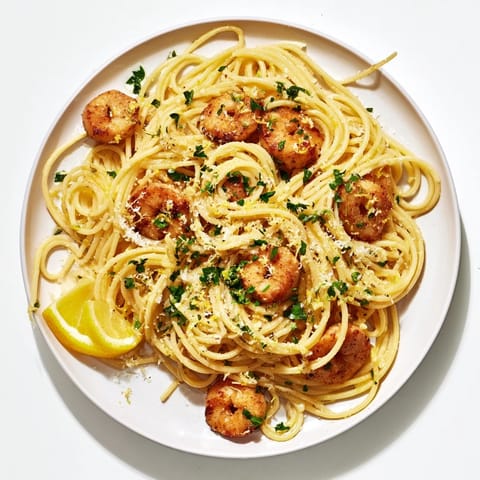 A close-up of Brown Butter Lemon Chicken Pasta shows golden chicken and bright lemon zest over spaghetti, with a serving fork ready to dig in.