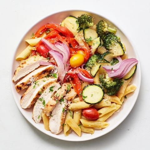 Savory Garlic Herb Chicken & Veg Pasta is served hot with a sprinkle of Parmesan and fresh parsley garnish.