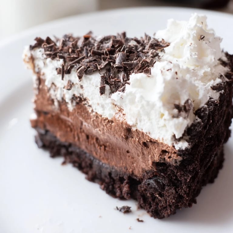 Garnished Mississippi Mud Pie, with whipped cream spirals, inviting a sweet, rich chocolate taste.