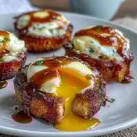 Classic Eggs Benedict with golden poached eggs and creamy hollandaise sauce served on toasted English muffins, perfect for brunch.