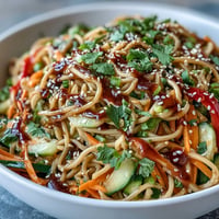 Vibrant cold soba noodle salad with crisp vegetables and zesty sesame ginger dressing.